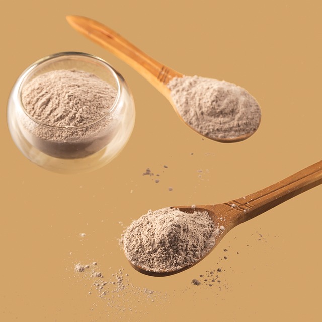 Powdered skincare ingredients in wooden spoons and a glass container, emphasizing natural formulations for personalized skincare routines.